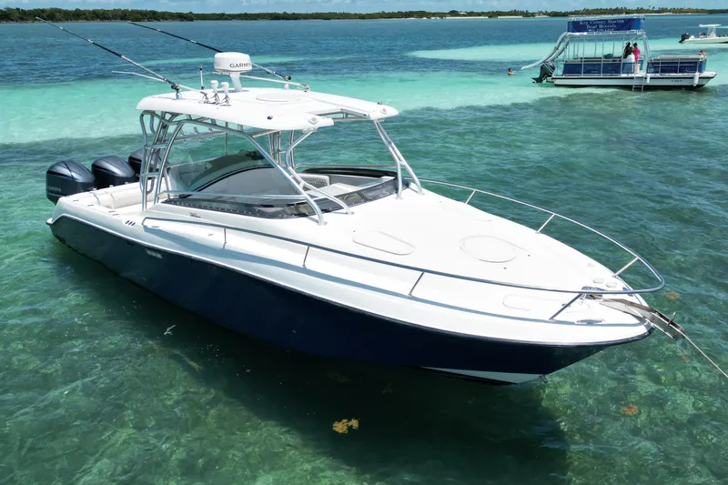 Slide: The Image of 2005 Hydra-Sports Vector 3300 VX boat on clear turquoise water, equipped with dual engines. - 3