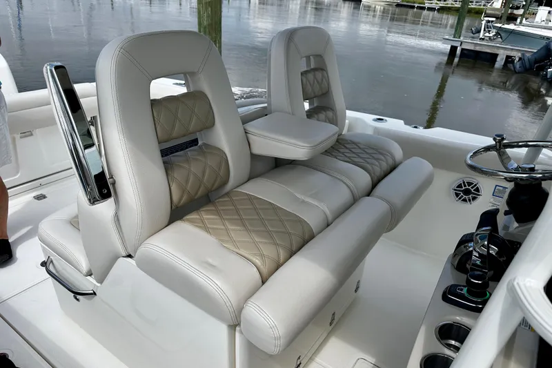 Slide: The Image of 2019 Boston Whaler 330 Outrage boat interior with luxurious seating and steering wheel. - 13