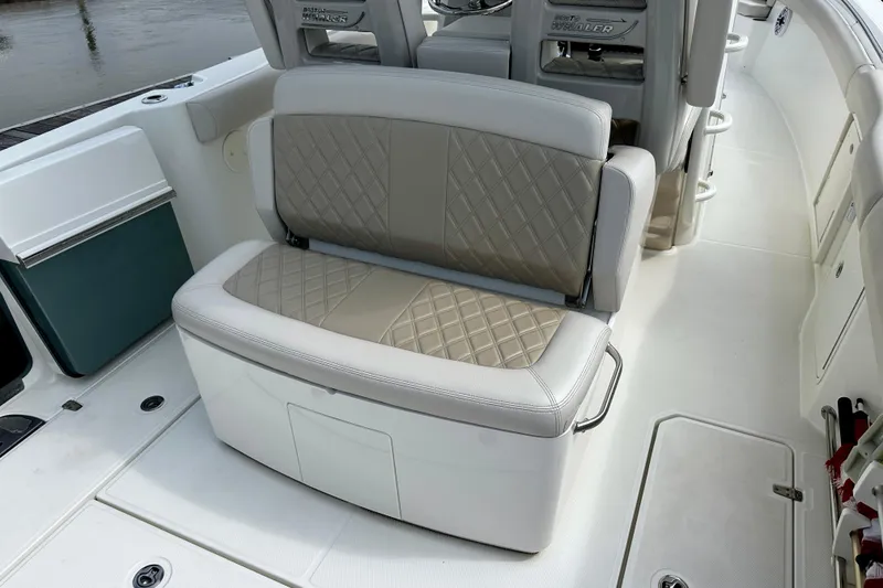 Slide: The Image of 2019 Boston Whaler 330 Outrage boat interior with cushioned seating and storage. - 14