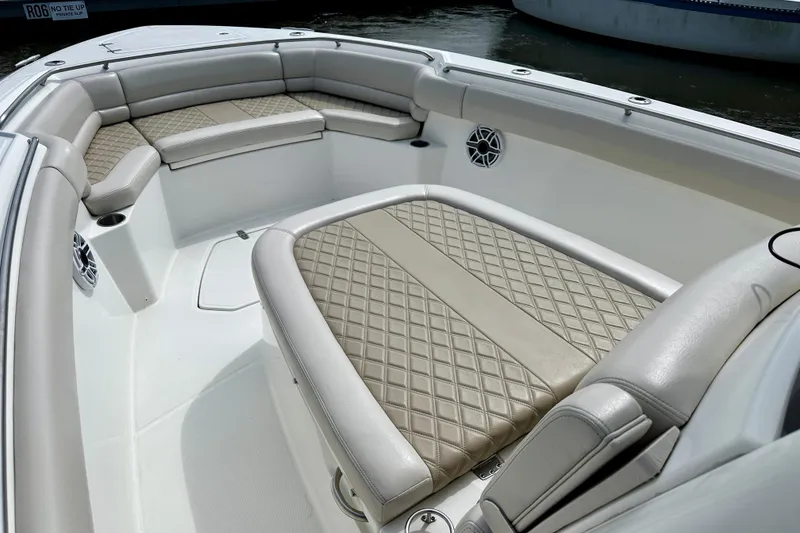 Slide: The Image of 2019 Boston Whaler 330 Outrage boat interior with cushioned seating and diamond-pattern upholstery. - 16