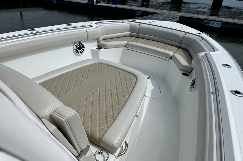 Slide: The Image of Luxurious seating area on a 2019 Boston Whaler 330 Outrage boat, docked by the water. - 17