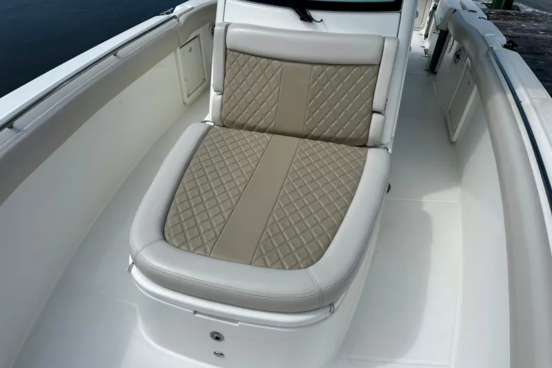 Slide: The Image of 2019 Boston Whaler 330 Outrage boat with cushioned seating and diamond-pattern upholstery. - 19