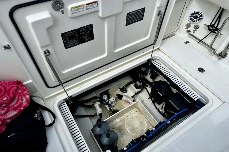 Slide: The Image of 2019 Boston Whaler 330 Outrage engine compartment, showcasing internal components and storage. - 27