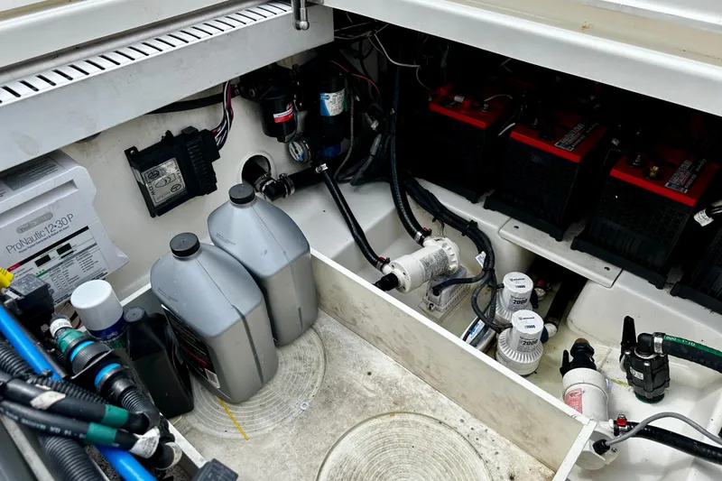 Slide: The Image of 2019 Boston Whaler 330 Outrage engine compartment with batteries and maintenance equipment. - 29