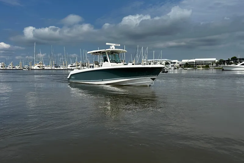 Slide: The Image of 2019 Boston Whaler 330 Outrage cruising in a marina under cloudy skies. - 3