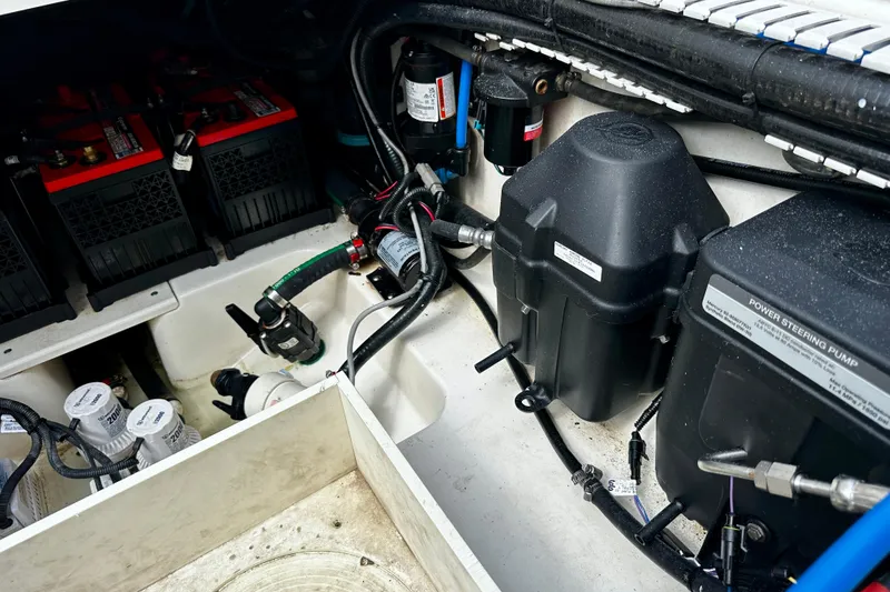 Slide: The Image of Engine compartment of a 2019 Boston Whaler 330 Outrage, showcasing batteries and power steering pump. - 30