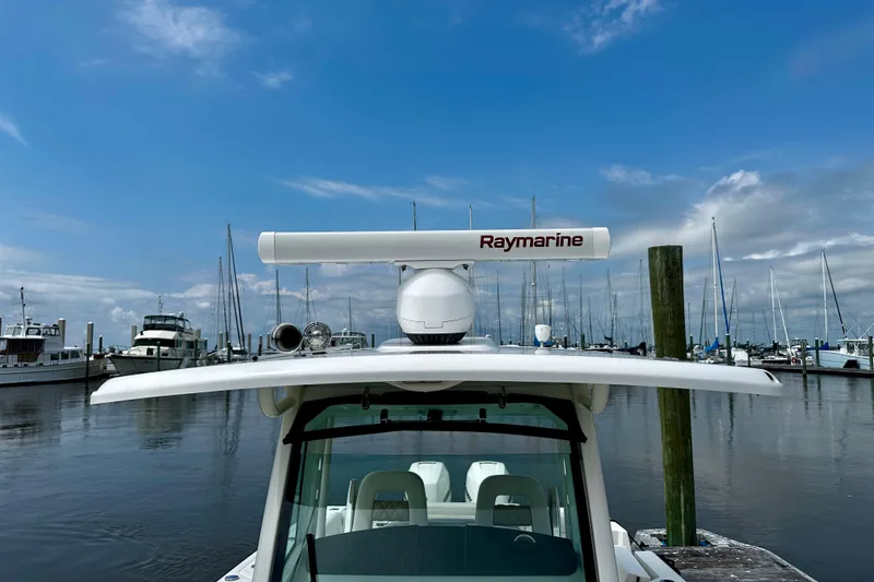 Slide: The Image of 2019 Boston Whaler 330 Outrage with Raymarine radar at marina under blue sky. - 32