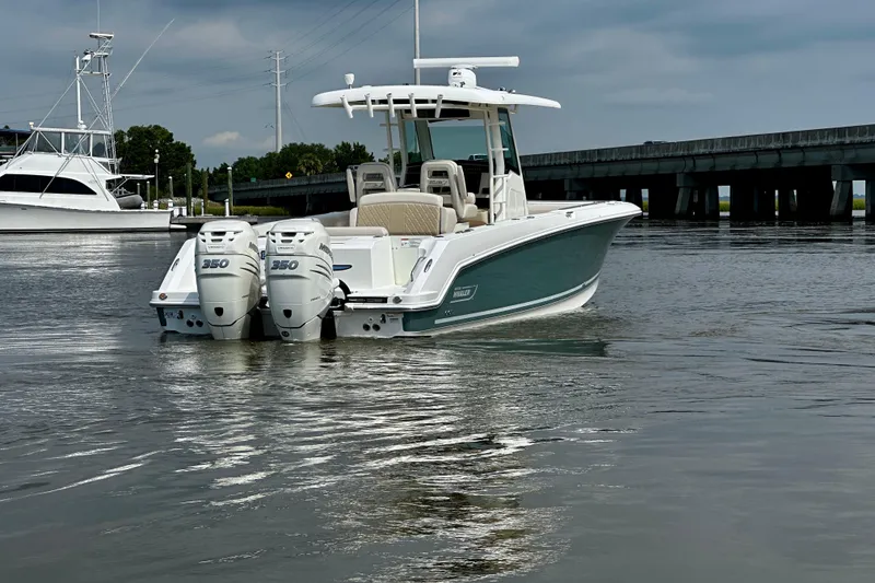 Slide: The Image of 2019 Boston Whaler 330 Outrage boat with twin 350 engines on calm water. - 4