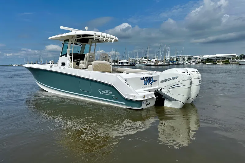 Slide: The Image of 2019 Boston Whaler 330 Outrage boat with twin Mercury engines on calm water. - 8