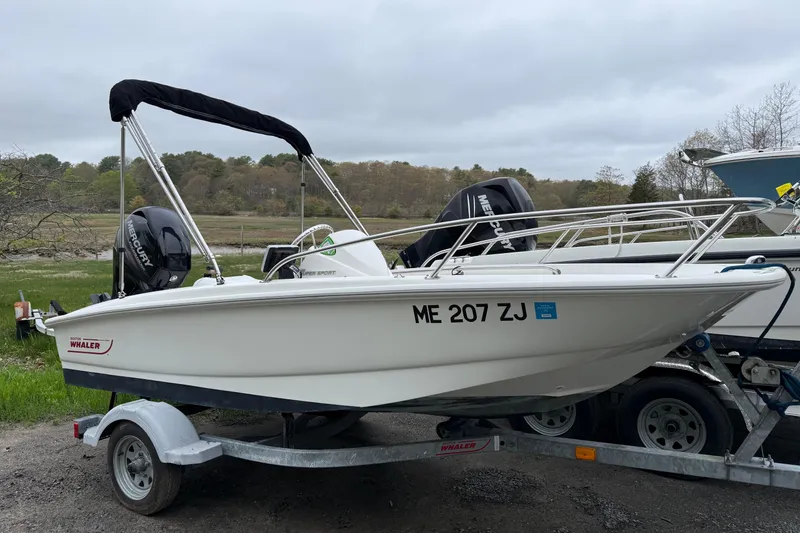 The Image of 2016 Boston Whaler 130 Super Sport boat on trailer, parked outdoors. - 0