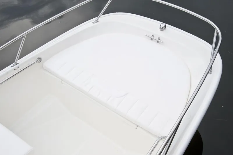 Slide: The Image of Manufacturer Provided Image: 2016 Boston Whaler 130 Super Sport boat interior with white seating and railing. - 7