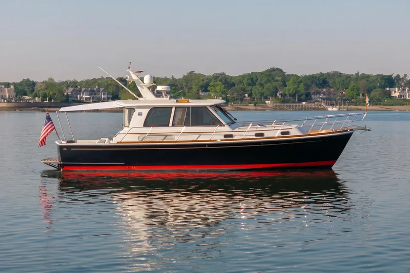 The Image of 2008 Grand Banks 45 Eastbay SX yacht on calm water, scenic shoreline background. - 0