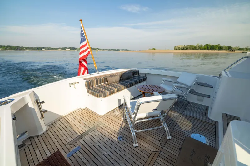 Slide: The Image of 2008 Grand Banks 45 Eastbay SX yacht deck with seating, American flag, and scenic water view. - 10