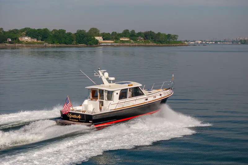 Slide: The Image of 2008 Grand Banks 45 Eastbay SX cruising on calm waters with scenic shoreline backdrop. - 6