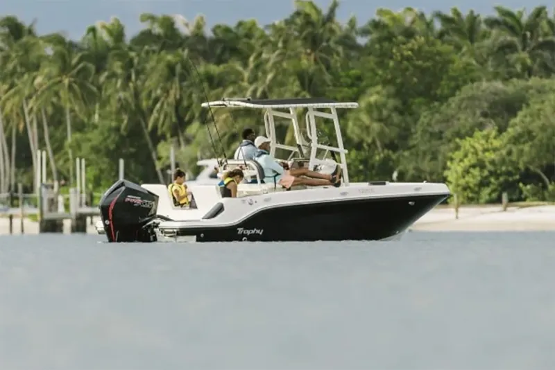 Slide: The Image of Manufacturer Provided Image: 2025 Bayliner Trophy T20CC boat cruising near tropical shoreline with palm trees. - 1
