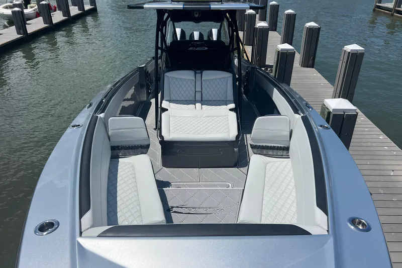 Slide: The Image of 2022 Nor-Tech 390 Sport Center Console boat with luxurious seating at a marina dock. - 11