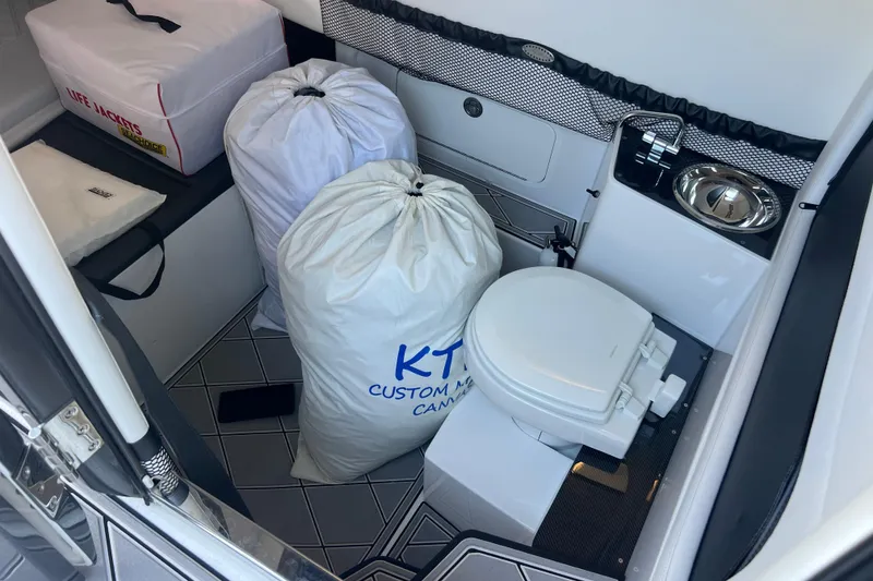 Slide: The Image of Interior of 2022 Nor-Tech 390 Sport Center Console with toilet and storage bags. - 17