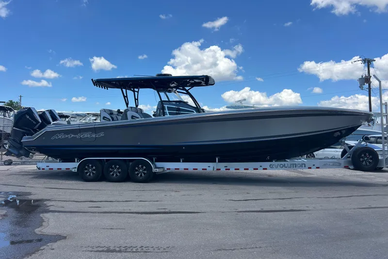 Slide: The Image of 2022 Nor-Tech 390 Sport Center Console boat on trailer under blue sky. - 2