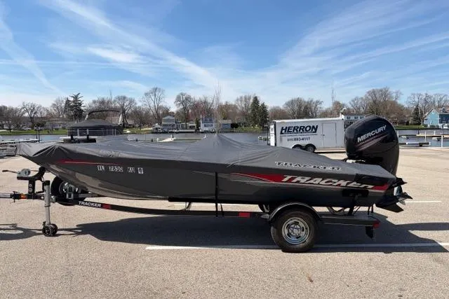 The Image of 2016 Tracker Pro Team 195 TXW Tournament Edition boat on trailer, covered, parked outdoors. - 1