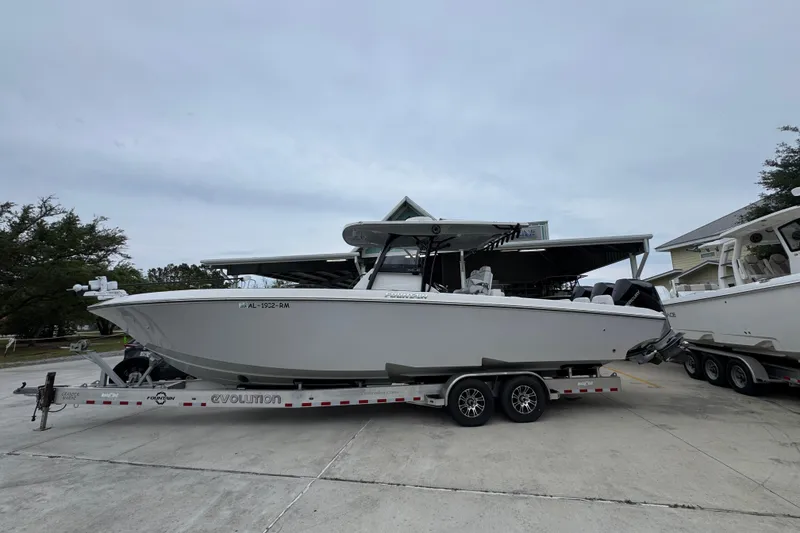The Image of 2021 Fountain 34 Center Console boat on trailer, parked outdoors. - 1