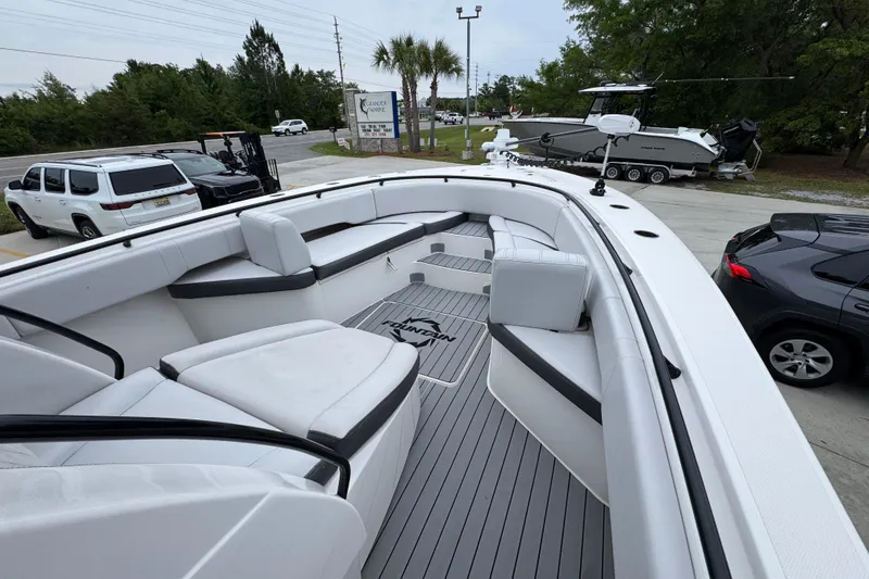 Slide: The Image of 2021 Fountain 34 Center Console boat with spacious seating, parked outdoors. - 15