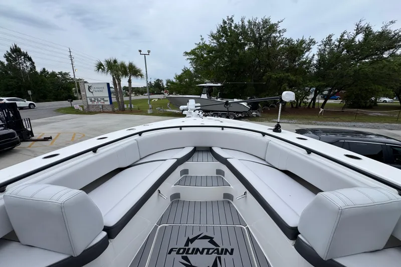 Slide: The Image of 2021 Fountain 34 Center Console boat with spacious seating and sleek design at a marina. - 16