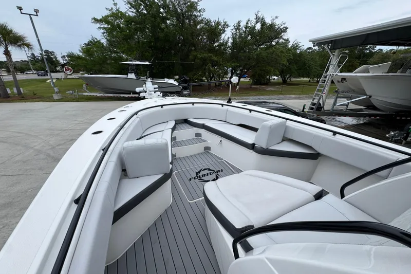 Slide: The Image of 2021 Fountain 34 Center Console boat with spacious seating and sleek design in a marina setting. - 17