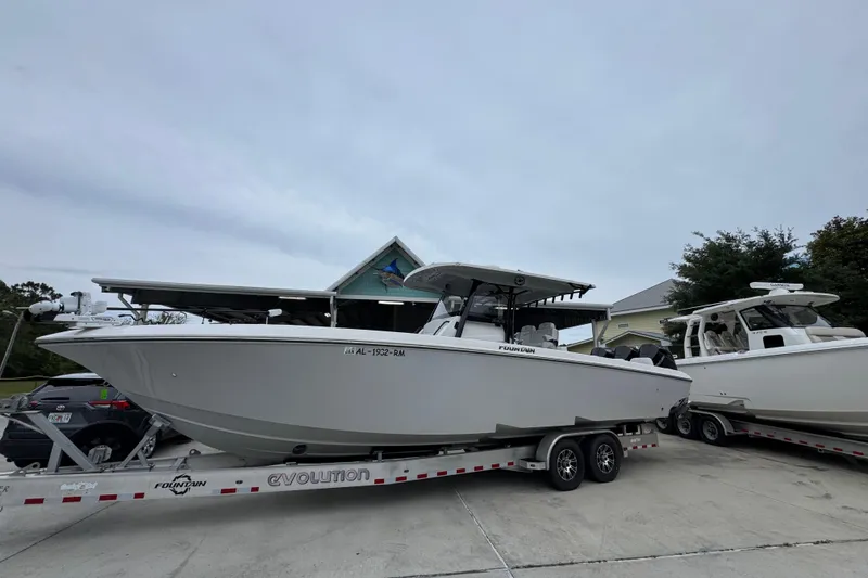 Slide: The Image of 2021 Fountain 34 Center Console boat on trailer, parked outdoors. - 2