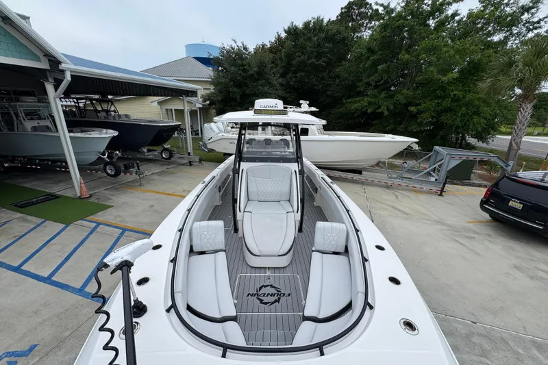 Slide: The Image of 2021 Fountain 34 Center Console boat in marina, showcasing sleek design and spacious seating. - 20