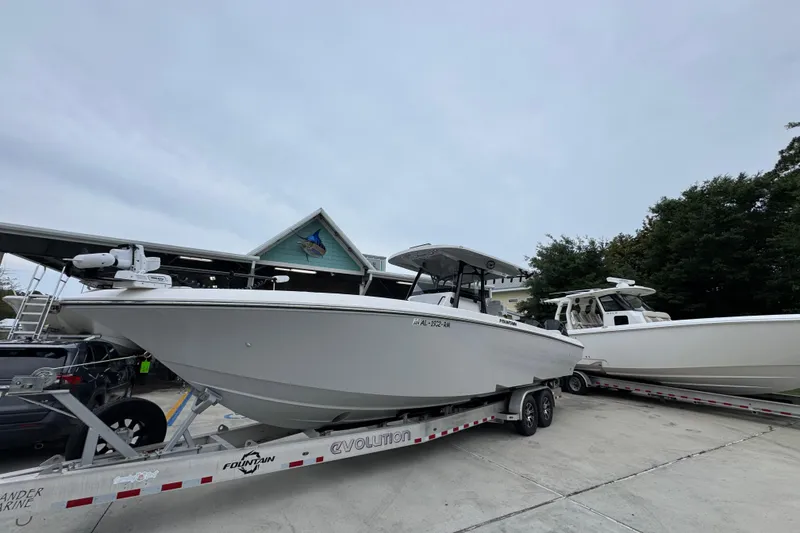 Slide: The Image of 2021 Fountain 34 Center Console boat on trailer, parked outdoors near other boats. - 3