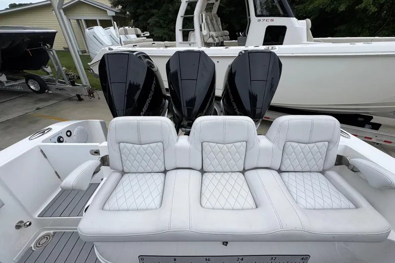 Slide: The Image of 2021 Fountain 34 Center Console boat with triple Mercury engines and white quilted seating. - 36