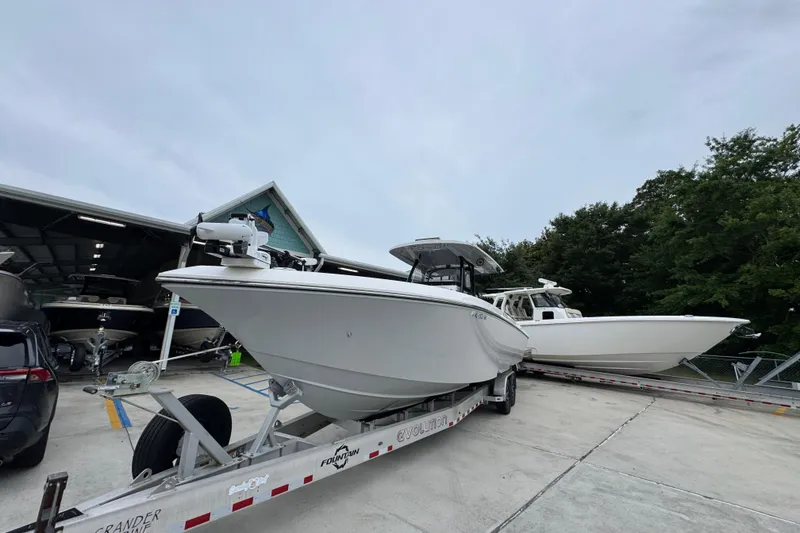 Slide: The Image of 2021 Fountain 34 Center Console boat on trailer, parked near a garage. - 4