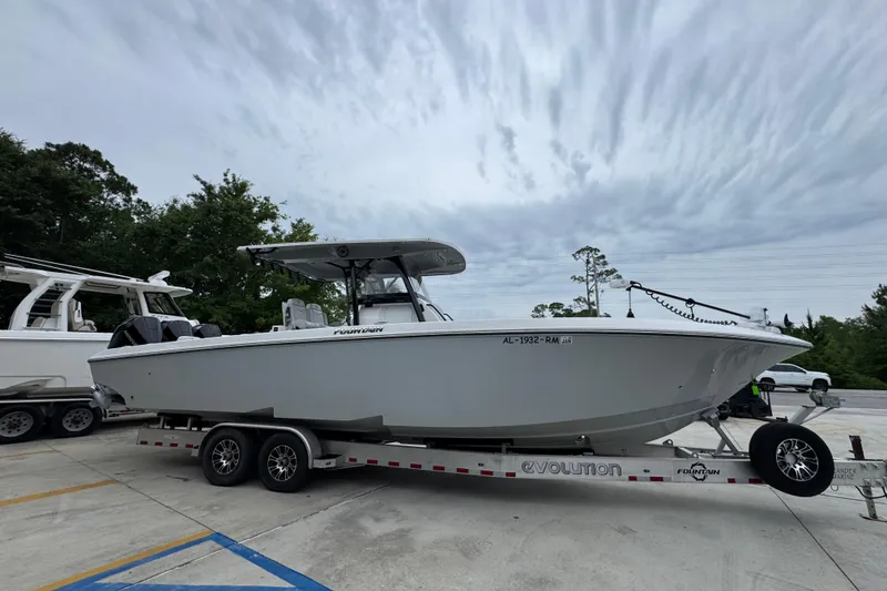 Slide: The Image of 2021 Fountain 34 Center Console boat on trailer, parked outdoors under cloudy sky. - 8