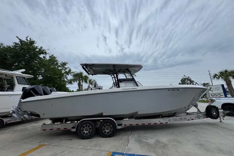 Slide: The Image of 2021 Fountain 34 Center Console boat on trailer, parked outdoors under cloudy sky. - 9