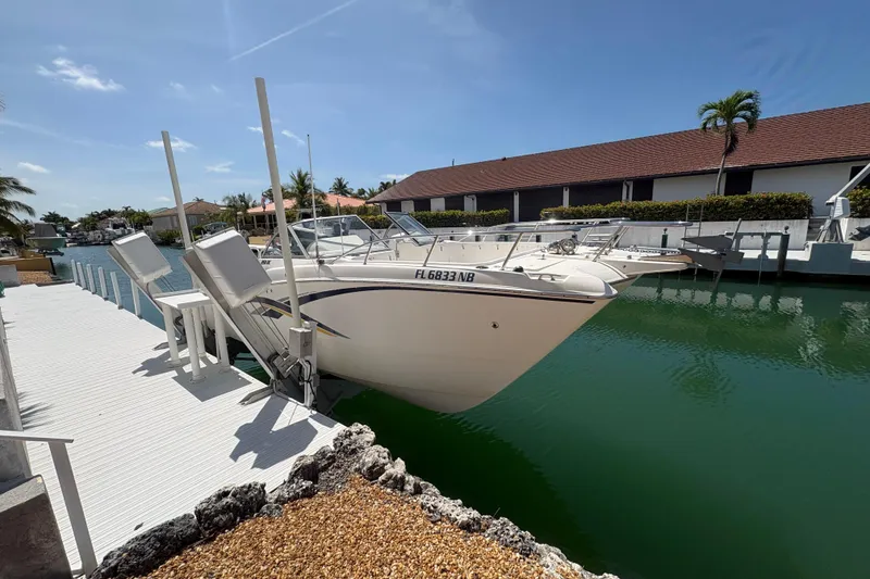 The Image of 2006 World Cat 250 DC boat docked in a sunny waterfront setting. - 1