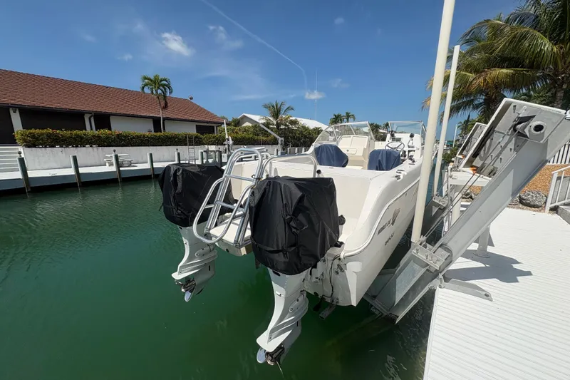 Slide: The Image of 2006 World Cat 250 DC boat docked, featuring dual engines and a sunny waterfront setting. - 3