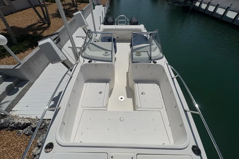 Slide: The Image of 2006 World Cat 250 DC boat docked, featuring spacious seating and dual consoles. - 7