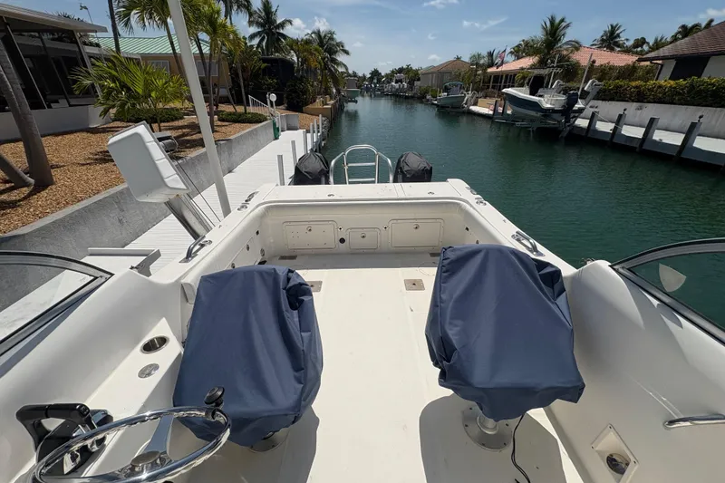 Slide: The Image of 2006 World Cat 250 DC boat docked in a scenic canal with palm trees. - 8