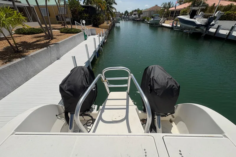 Slide: The Image of 2006 World Cat 250 DC boat docked in a serene canal setting. - 9