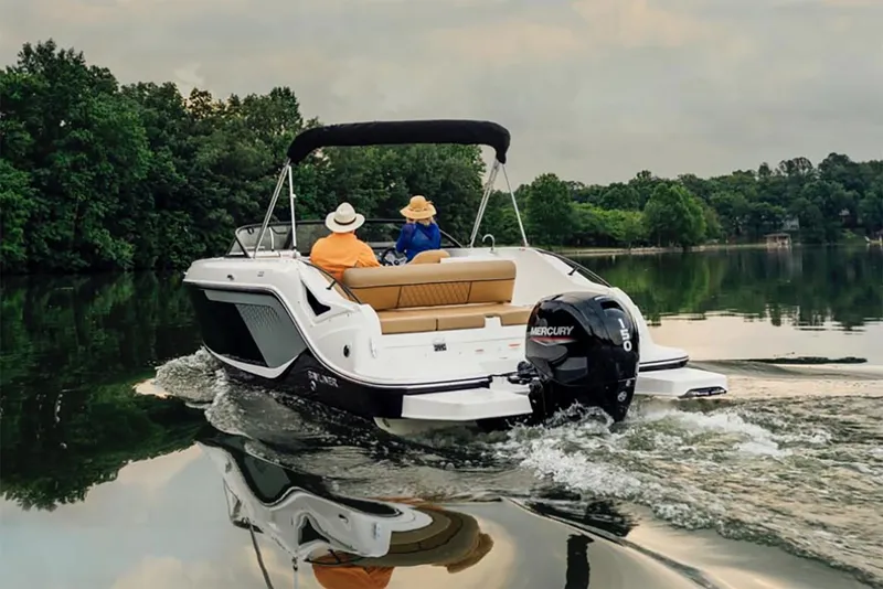 Slide: The Image of Manufacturer Provided Image: 2025 Bayliner D22 boat cruising on a serene lake with two passengers. - 1