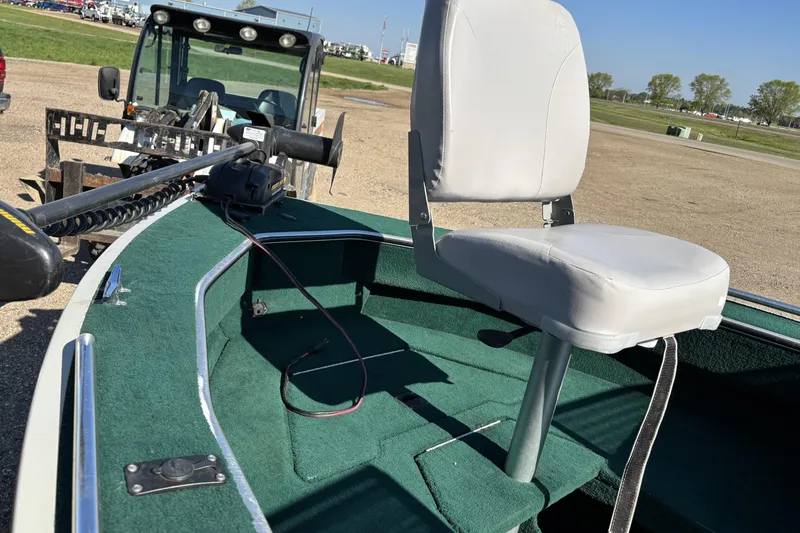 Slide: The Image of 2003 MirroCraft 1737 Holiday boat with green carpet and white seat, parked outdoors. - 10