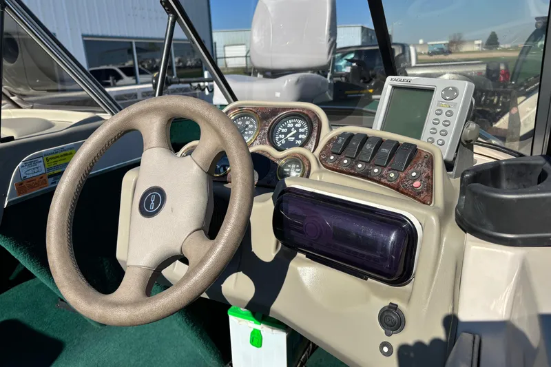 Slide: The Image of 2003 MirroCraft 1737 Holiday boat dashboard with steering wheel and navigation controls. - 13