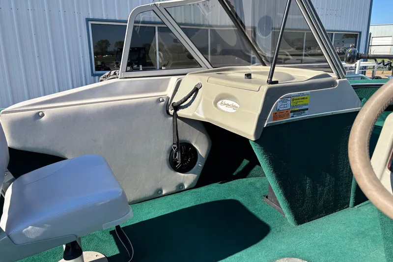Slide: The Image of 2003 MirroCraft 1737 Holiday boat interior with green carpet and steering console. - 14