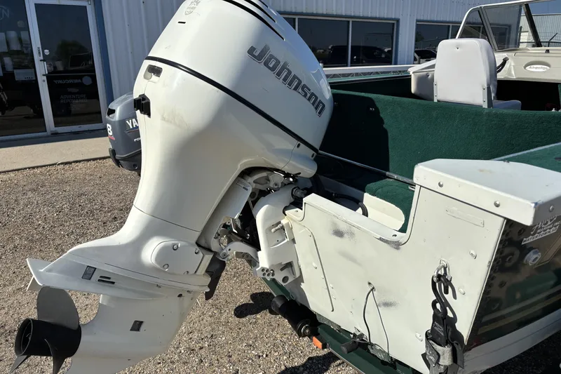 Slide: The Image of 2003 MirroCraft 1737 Holiday boat with Johnson outboard motor, parked outdoors. - 6