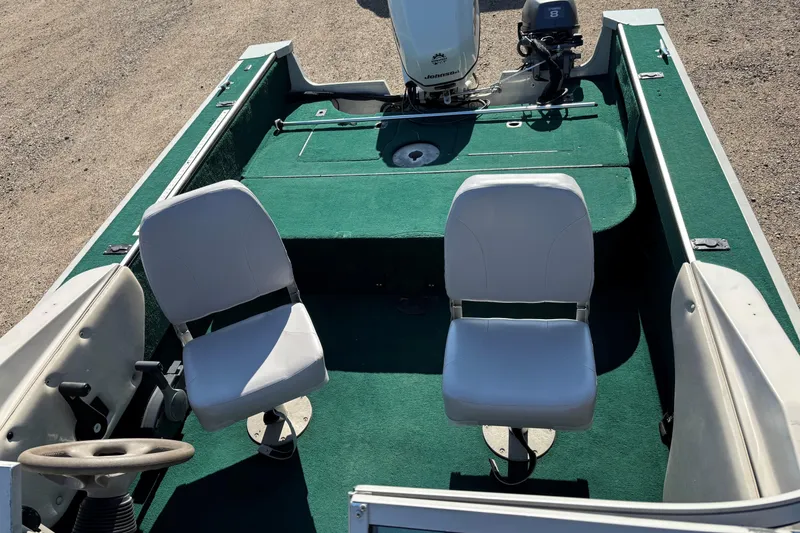 Slide: The Image of 2003 MirroCraft 1737 Holiday boat interior with green carpet and two white seats. - 8