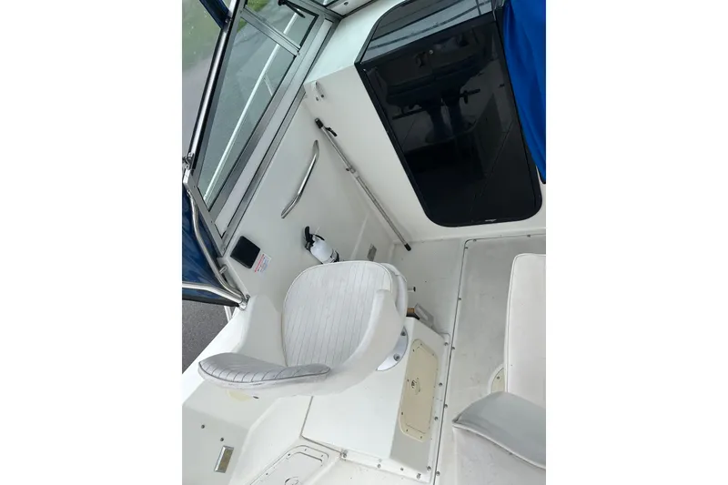 Slide: The Image of Interior of a 1995 Celebrity 2500 Fish Hawk boat, featuring seating and cabin entrance. - 10