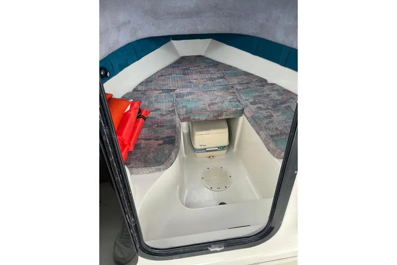 Slide: The Image of Interior cabin of a 1995 Celebrity 2500 Fish Hawk boat with seating and storage. - 15