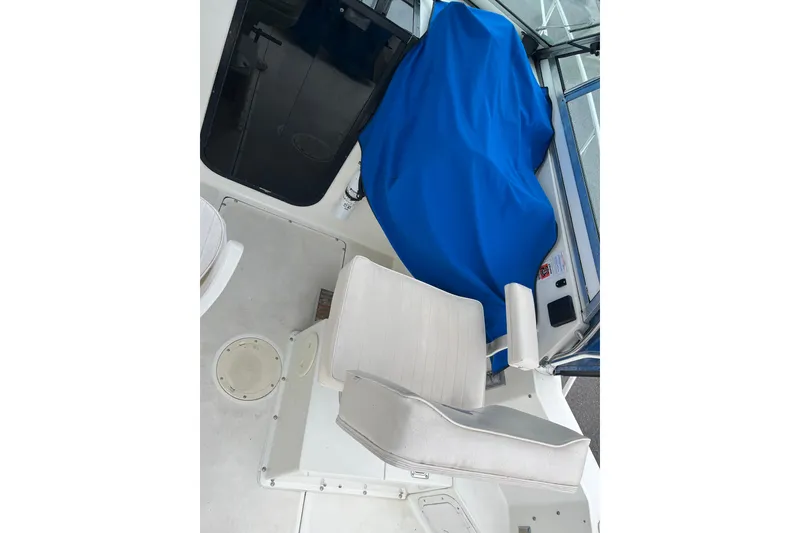 Slide: The Image of Interior of a 1995 Celebrity 2500 Fish Hawk boat with seating and blue cover. - 16