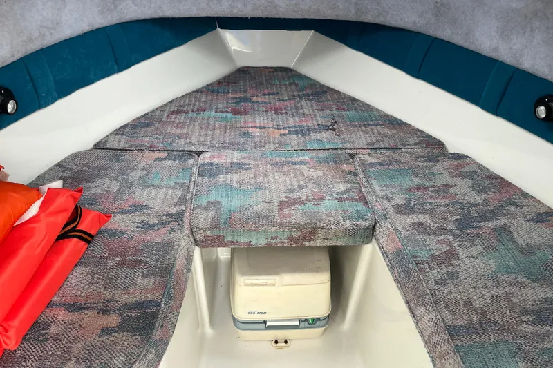 Slide: The Image of Interior of a 1995 Celebrity 2500 Fish Hawk boat with patterned cushions and storage. - 18