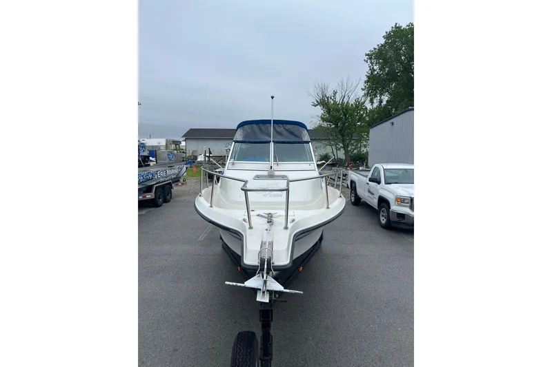 Slide: The Image of 1995 Celebrity 2500 Fish Hawk boat on trailer in parking lot. - 2